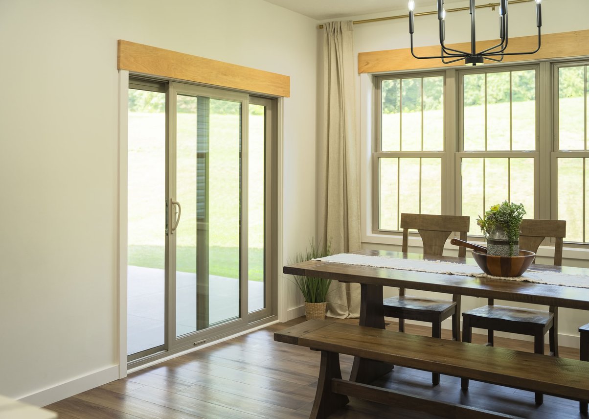 Dining room with sliding glass door and wood furniture.